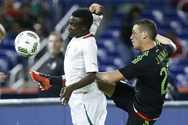 Mexico's Jesus Duenas (20) and Senegal's Elimane Oumar Cisse (6) battle for the ball during the first half of a soccer match at Marlins Park, Wednesday, Feb. 10, 2016, in Miami. (AP Photo/Wilfredo Lee)