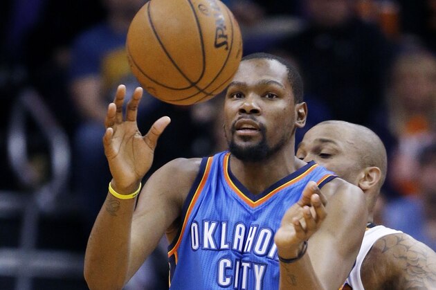 Oklahoma City Thunder's Kevin Durant (35) reaches out to catch a pass in front of Phoenix Suns' P.J. Tucker, right, during the second half of an NBA basketball game Monday, Feb. 8, 2016, in Phoenix.  The Thunder defeated the Suns 122-106. (AP Photo/Ross D. Franklin)
