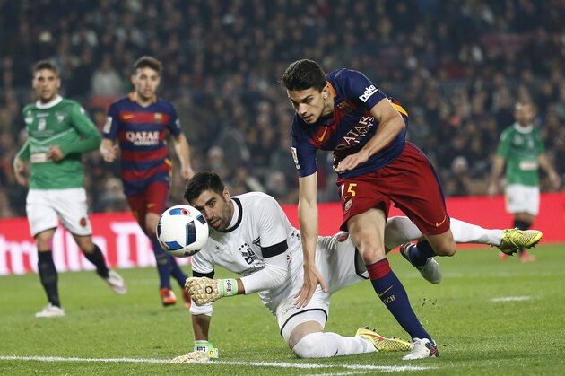 FC Barcelona's Marc Bartra, right, duels for the ball against Villanovense's goalkeeper Jose Fuentes during a Copa del Rey soccer match at the Camp Nou stadium in Barcelona, Spain, Wednesday, Dec. 2, 2015. (AP Photo/Manu Fernandez)