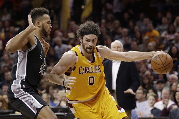 Cleveland Cavaliers' Kevin Love (0) drives past San Antonio Spurs' Kyle Anderson (1) in the first half of an NBA basketball game Saturday, Jan. 30, 2016, in Cleveland. (AP Photo/Tony Dejak)