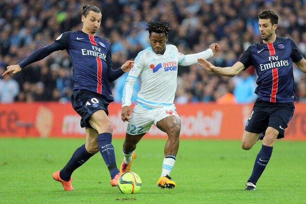 Marseille's Michy Batshuayi, center,  challenges for the ball with Paris Saint Germain's Zlatan Ibrahimovic, left, and Thiago Motta, during the League One soccer match between Marseille and Paris Saint-Germain, at the Velodrome Stadium, in Marseille, southern France, Sunday, Feb. 7, 2016. (AP Photo/Claude Paris)