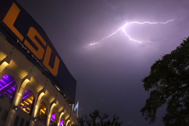 Lightning bolts are seen over Tiger Stadium during a weather delay at an NCAA college football game between LSU and McNeese State in Baton Rouge, La., Saturday, Sept. 5, 2015. The game was canceled due to weather. (AP Photo/Jonathan Bachman)