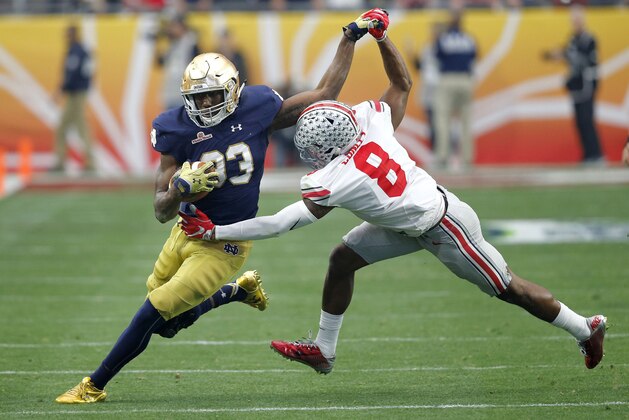 Notre Dame running back Josh Adams (33) is hit by Ohio State cornerback Gareon Conley (8) during the first half of the Fiesta Bowl NCAA College football game, Friday, Jan. 1, 2016, in Glendale, Ariz.  (AP Photo/Ross D. Franklin)