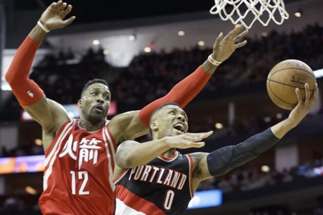 Portland Trail Blazers' Damian Lillard (0) goes to the basket ahead of Houston Rockets' Dwight Howard (12) in the first half of an NBA basketball game Saturday, Feb. 6, 2016, in Houston. (AP Photo/Pat Sullivan)