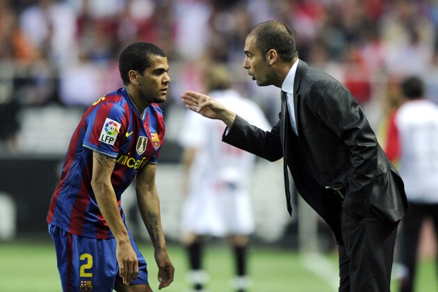 Barcelona's coach Pep Guardiola (R) speaks with Barcelona's Brazilian defender Dani Alves (L) during their Spanish league football match beetwen Sevilla and Barcelona at Sanchez Pizjuan stadium in Sevilla on May 8, 2010. AFP PHOTO / JAVIER SORIANO (Photo credit should read JAVIER SORIANO/AFP/Getty Images)