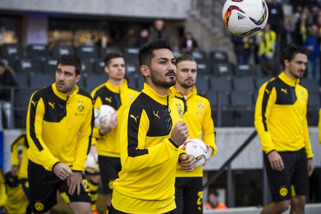 Dortmund's midfielder Ilkay Guendogan (C ) and team mates walk onto the pitch prior to the German first division Bundesliga football match, Hertha Berlin v Borussia Dortmund, at the Olympic stadium in Berlin on February 6, 2016.  / AFP / ODD ANDERSEN / RESTRICTIONS: DURING MATCH TIME: DFL RULES TO LIMIT THE ONLINE USAGE TO 15 PICTURES PER MATCH AND FORBID IMAGE SEQUENCES TO SIMULATE VIDEO. == RESTRICTED TO EDITORIAL USE == FOR FURTHER QUERIES PLEASE CONTACT DFL DIRECTLY AT + 49 69 650050
        (Photo credit should read ODD ANDERSEN/AFP/Getty Images)