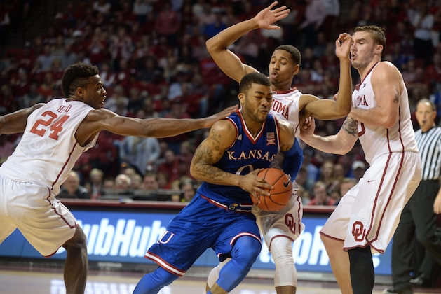 Feb 13, 2016; Norman, OK, USA; Kansas Jayhawks guard Frank Mason III (0) drives to the basket against Oklahoma Sooners guard Buddy Hield (24) and Oklahoma Sooners guard Isaiah Cousins (11) during the first half at Lloyd Noble Center. Mandatory Credit: Mark D. Smith-USA TODAY Sports