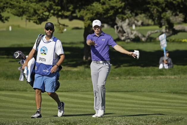 Jordan Spieth, right, walks with his caddy Michael Greller, left, up to the second green of the Pebble Beach Golf Links during the third round of the AT&T Pebble Beach National Pro-Am golf tournament Saturday, Feb. 13, 2016, in Pebble Beach, Calif. (AP Photo/Eric Risberg)