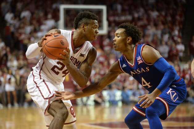 Feb 13, 2016; Norman, OK, USA; Oklahoma Sooners guard Buddy Hield (24) handles the ball against Kansas Jayhawks guard Devonte' Graham (4) during the first half at Lloyd Noble Center. Mandatory Credit: Mark D. Smith-USA TODAY Sports