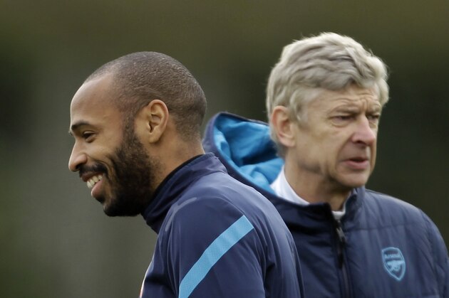 Arsenal's on loan former player, and the club's all time highest scorer, Thierry Henry, left, stands near the club's French manager Arsene Wenger during a training session at the club's facilities in London Colney, England, Tuesday, Feb. 14, 2012.  Arsenal are due to play AC Milan in the first leg of their Champions League last 16 soccer match in Milan on Wednesday.  (AP Photo/Matt Dunham)