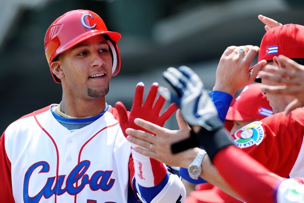 MEXICO CITY - MARCH 08:  Yulieski Gourriel #10 of Cuba is congratulated by his teammates after hitting a home run against South Africa during the 2009 World Baseball Classic Pool B match on March 8, 2009 at the Estadio Foro Sol in Mexico City, Mexico.  (Photo by Kevork Djansezian/Getty Images)