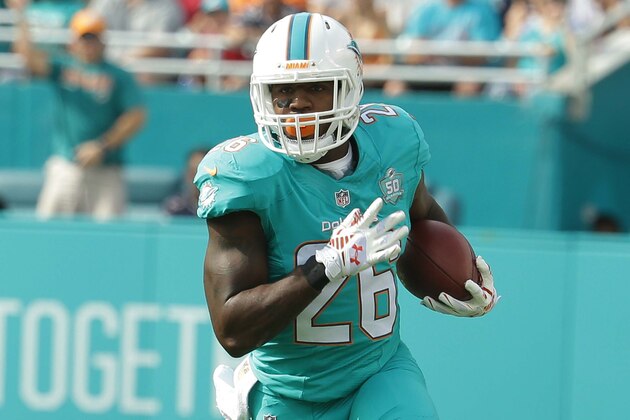 Miami Dolphins running back Lamar Miller (26) carries the ball during the first half of an NFL football game against the New England Patriots, Sunday, Jan. 3, 2016 in Miami Gardens, Fla. (AP Photo/Wilfredo Lee)