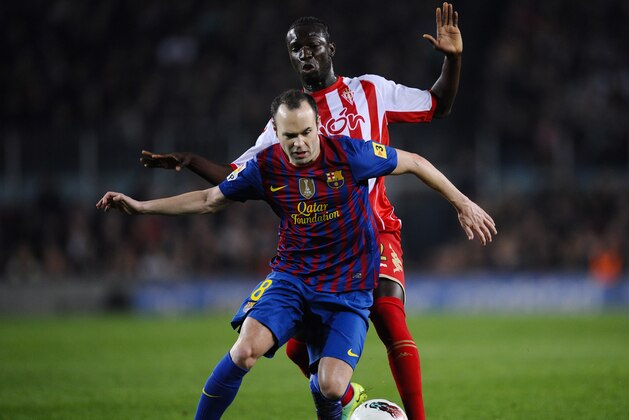 BARCELONA, SPAIN - MARCH 03:  Andres Iniesta of FC Barcelona duels for the ball with Formose Mendy of Sporting de Gijon during the La Liga match between FC Barcelona and Sporting Gijon at Camp Nou on March 3, 2012 in Barcelona, Spain.  (Photo by David Ramos/Getty Images)