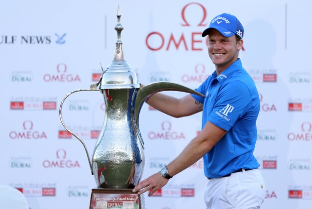 Danny Willett of England poses with the trophy after he won the Dubai Desert Classic golf tournament in Dubai, United Arab Emirates, Sunday, Feb. 7, 2016. (AP Photo/Kamran Jebreili)