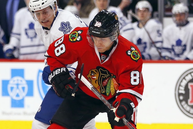 Chicago Blackhawks right wing Patrick Kane (88) battles Toronto Maple Leafs left wing Colin Greening (38) during the first period of an NHL hockey game on Monday, Feb. 15, 2016, in Chicago. (AP Photo/Jeff Haynes)