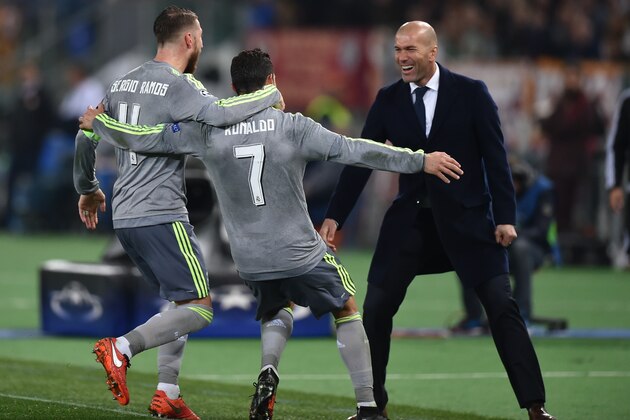 Real Madrid's Portuguese forward Cristiano Ronaldo (C) celebrates with Real Madrid's defender Sergio Ramos and Real Madrid's French coach Zinedine Zidane after scoring during the UEFA Champions League football match AS Roma vs Real Madrid on Frebruary 17, 2016 at the Olympic stadium in Rome.     AFP PHOTO / ALBERTO PIZZOLI / AFP / ALBERTO PIZZOLI        (Photo credit should read ALBERTO PIZZOLI/AFP/Getty Images)