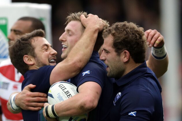 Scotland's Finn Russell, centre, celebrates scoring a try with teammates captain Greig Laidlaw, left, and Fraser Brown during the Rugby World Cup Pool B match between Scotland and Japan at Kingsholm, Gloucester, England, Wednesday, Sept. 23, 2015. (AP Photo/Clint Hughes)