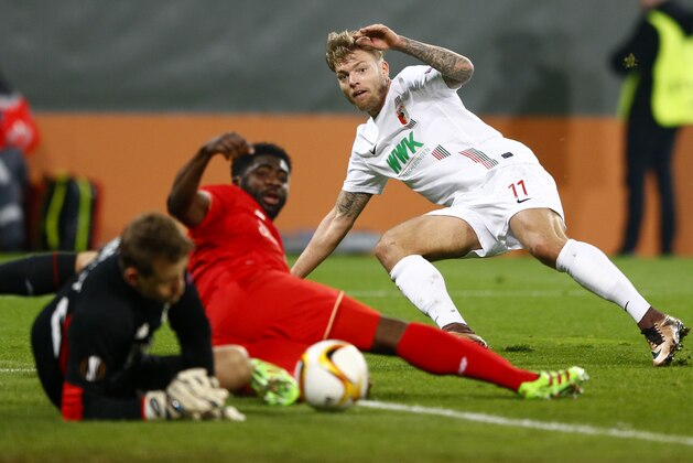 Liverpool goalkeeper Simon Mignolet, left, saves the ball from Augsburg's Alexander Esswein besides teammate Kolo Toure during the Europa League soccer match between FC Augsburg and FC Liverpool in Augsburg, southern Germany, Thursday, Feb. 18, 2016. (AP Photo/Matthias Schrader)