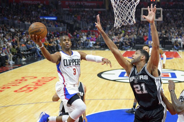 Los Angeles Clippers guard Chris Paul, left, shoots as San Antonio Spurs center Tim Duncan defends during the first half of an NBA basketball game Thursday, Feb. 18, 2016, in Los Angeles. (AP Photo/Mark J. Terrill)