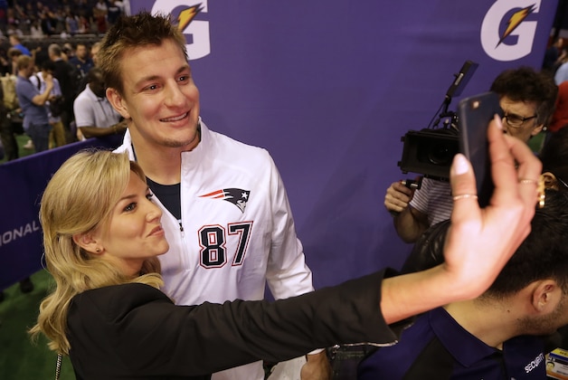 FILE - In this Jan. 27, 2015, file photo, New England Patriots' Rob Gronkowski poses for a selfie with television host and sportscaster Charissa Thompson during media day for NFL Super Bowl XLIX football game in Phoenix. Men are behind more news stories than women by a nearly 2-to-1 margin across print and television platforms, though there was a slight increase in bylines and credits for women last year, a new study says. The Washington-based Women's Media Center released its study Thursday, June 4, 2015,  as part of its fourth annual report on