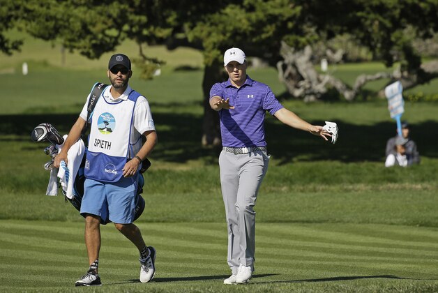 Jordan Spieth, right, walks with his caddy Michael Greller, left, up to the second green of the Pebble Beach Golf Links during the third round of the AT&T Pebble Beach National Pro-Am golf tournament Saturday, Feb. 13, 2016, in Pebble Beach, Calif. (AP Photo/Eric Risberg)