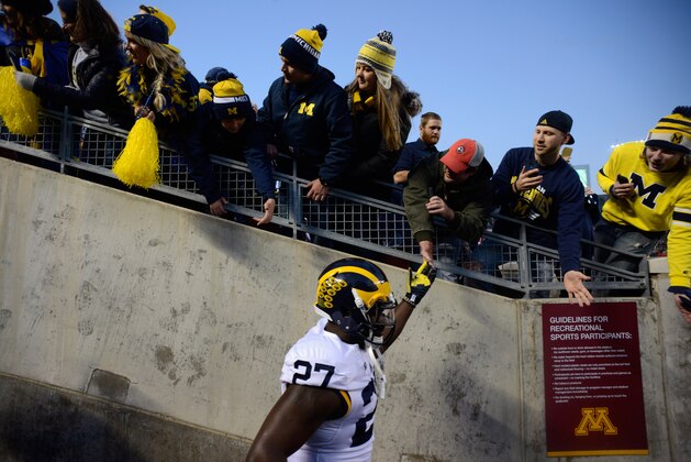 MINNEAPOLIS, MN - OCTOBER 31: Derrick Green #27 of the Michigan Wolverines high fives fans as he runs onto the field before the game against the Minnesota Golden Gophers on October 31, 2015 at TCF Bank Stadium in Minneapolis, Minnesota. (Photo by Hannah Foslien/Getty Images)