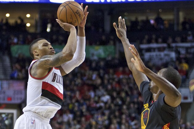 Portland Trail Blazers guard Damian Lillard, left, shoots over Golden State Warriors forward Harrison Barnes, right, during the second half of an NBA basketball game in Portland, Ore., Friday, Feb. 19, 2016. (AP Photo/Craig Mitchelldyer)
