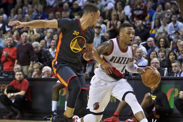 Portland Trail Blazers guard Damian Lillard moves the ball past Golden State Warriors guard Stephen Curry, left, during the second half of an NBA basketball game in Portland, Ore., Friday, Feb. 19, 2016. (AP Photo/Craig Mitchelldyer)
