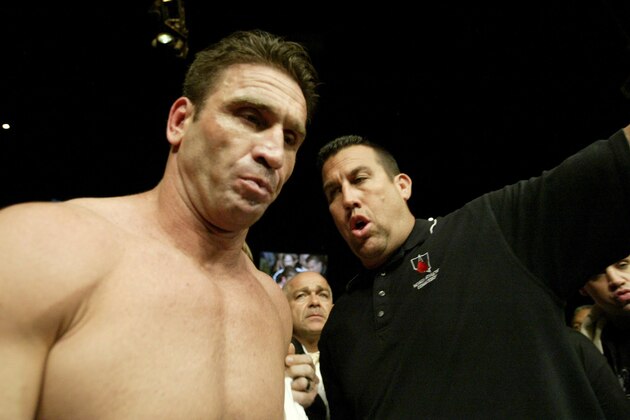 John McCarthy guides Ken Shamrock into the arena to fight Tito Ortiz for the light heavyweight bout as part of the Ultimate Fighting Championship 61 in Las Vegas on Saturday, July 8, 2006. Ortiz defeated Ken Shamrock in the bout. (AP Photo/Jane Kalinowsky)