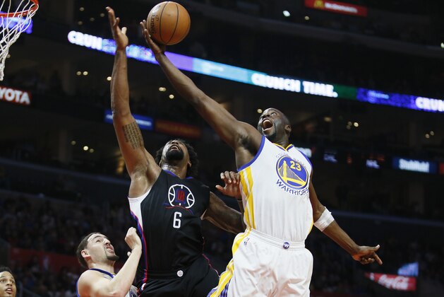 Golden State Warriors' Draymond Green, right, reaches for a rebound over Los Angeles Clippers' DeAndre Jordan, center, and Warriors' Klay Thompson, left, during the first half of an NBA basketball game Saturday, Feb. 20, 2016, in Los Angeles. (AP Photo/Danny Moloshok)