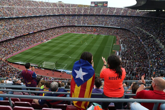 A Barcelona supporter stands drapped in the 'Estelada', pro-independent Catalonia flags, during the Spanish league football match FC Barcelona vs UD Las Palmas at the Camp Nou stadium in Barcelona on September 26, 2015. AFP PHOTO / CESAR MANSO        (Photo credit should read CESAR MANSO/AFP/Getty Images)
