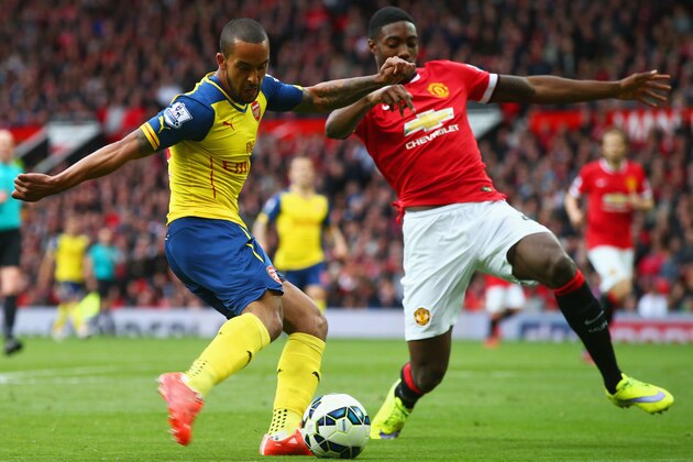 MANCHESTER, ENGLAND - MAY 17:  Theo Walcott of Arsenal crosses the ball which deflects of off Tyler Blackett of Manchester United for an own goal during the Barclays Premier League match between Manchester United and Arsenal at Old Trafford on May 17, 2015 in Manchester, England.  (Photo by Clive Rose/Getty Images)