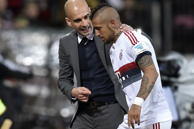 Bayern's head coach Pep Guardiola speaks to Bayern's Arturo Vidal during the German Bundesliga soccer match between Bayer Leverkusen and Bayern Munich in Leverkusen, Germany, Saturday, Feb. 6, 2016. (AP Photo/Martin Meissner)