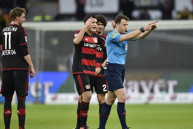 Referee Felix Zwayer, right, breaks up the German Bundesliga soccer match between Bayer Leverkusen and Borussia Dortmund in Leverkusen, Germany, Sunday, Feb. 21, 2016. (AP Photo/Martin Meissner)