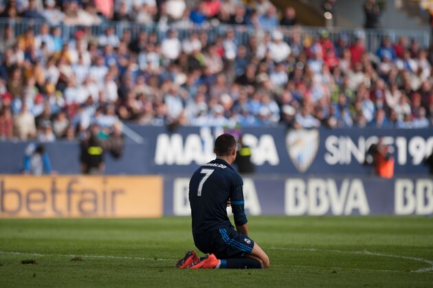 Real Madrid's Portuguese forward Cristiano Ronaldo kneels on the field during the Spanish league football match Malaga CF vs Real Madrid CF at La Rosaleda stadium in Malaga on February 21, 2016. / AFP / JORGE GUERRERO        (Photo credit should read JORGE GUERRERO/AFP/Getty Images)