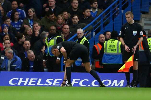 LONDON, ENGLAND - FEBRUARY 21 :  Referee Andre Marriner picks up items thrown onto the pitch after David Faupala of Manchester City scores to make it 1-1 during the Emirates FA Cup match between Chelsea and Manchester City at Stamford Bridge on February 21, 2016 in London, England.  (Photo by Catherine Ivill - AMA/Getty Images)
