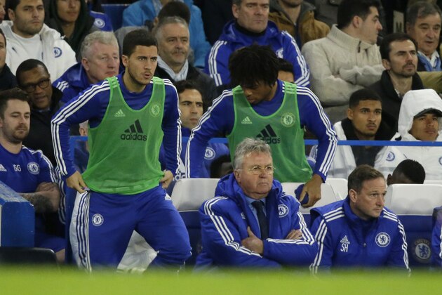 Chelsea's manager until the end of the season Guus Hiddink, center bottom, watches as substitutes Eden Hazard, left, and Loic Remy get up to warm up during the English Premier League soccer match between Chelsea and Watford at Stamford Bridge stadium in London, Saturday, Dec. 26, 2015.  (AP Photo/Matt Dunham)