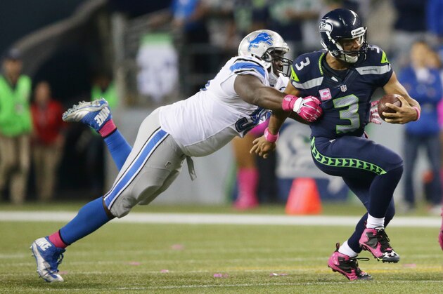 Seattle Seahawks quarterback Russell Wilson, right, is tackled by Detroit Lions defensive tackle Tyrunn Walker in the second half of an NFL football game, Monday, Oct. 5, 2015, in Seattle. (AP Photo/Scott Eklund)