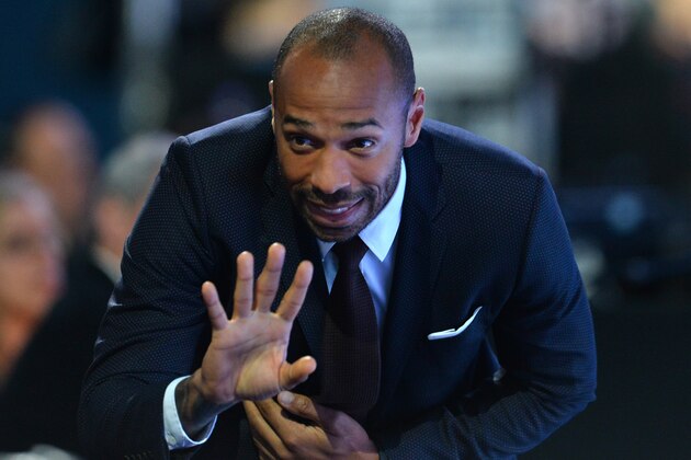 Former French international Thierry Henry waves during a men's singles semi-final match between Switzerland's Roger Federer and Switzerland's Stan Wawrinka on day seven of the ATP World Tour Finals tennis tournament in London on November 21, 2015. 
 / AFP / GLYN KIRK        (Photo credit should read GLYN KIRK/AFP/Getty Images)