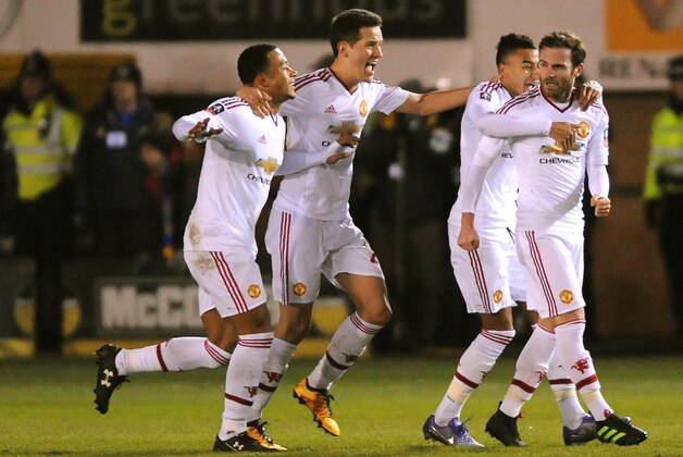 Manchester United players celebrate after Manchester United’s Juan Mata, right, scored during the English FA Cup fifth round soccer match between Shrewsbury Town and Manchester United at Greenhous Meadow stadium in Shrewsbury, England, Monday, Feb. 22, 2016. (AP Photo/Rui Vieira)