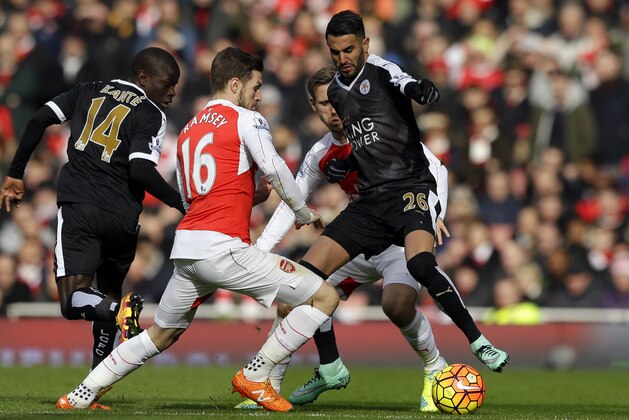 Leicester City's Riyad Mahrez, right, challenges Arsenal's  Aaron Ramsey during the English Premier League soccer match between Arsenal and Leicester City at the Emirates Stadium in London, Sunday, Feb. 14, 2016.  (AP Photo/Matt Dunham)