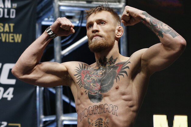 Conor McGregor stands on stage during the weigh-in for UFC 194 Friday, Dec. 11, 2015, in Las Vegas. McGregor is scheduled to fight Jose Aldo in a featherweight championship bout Saturday in Las Vegas. (AP Photo/John Locher)