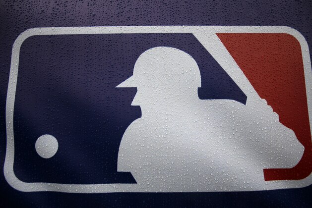 Rain drops cover the Major League Baseball logo before the start of Game 3 of the American League baseball championship series between the Baltimore Orioles and the Kansas City Royals Monday, Oct. 13, 2014, in Kansas City, Mo. The Royals lead the series 2-0. (AP Photo/Matt Slocum )