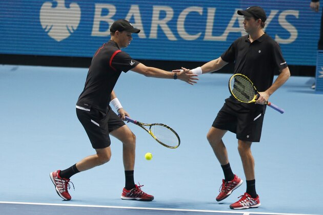 Bob Bryan, left,  and his brother and playing partner Mike Bryan of the United States touch hands as they play against Jamie Murray of Britain and John Peers of the United States during their men's double tennis match at the ATP World Tour Finals at the O2 Arena in London, Thursday, Nov. 19, 2015. (AP Photo/Alastair Grant)