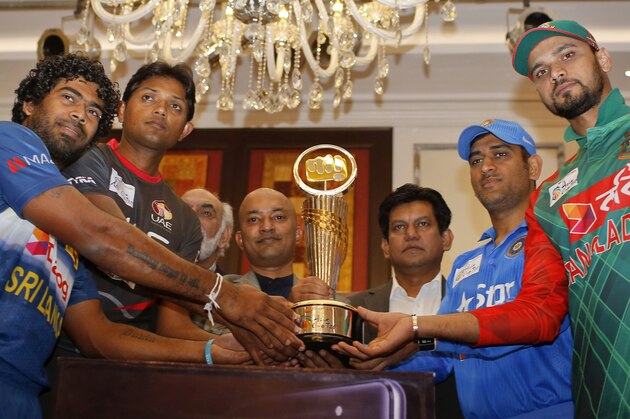 Bangladesh cricket team captain Mashrafe Mortaza, right, India cricket team captain MS Dhoni, second from right, Sri Lanka cricket team captain Lasith Malinga, left, and United Arab Emirates cricket team captain Amjad Javed, second from left, pose with the Asia Cup tournament trophy with two unidentified officials, in Dhaka, Bangladesh, Tuesday, Feb. 23, 2016. (AP Photo/A.M. Ahad)