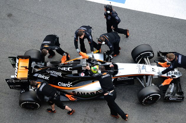 Mechanics work on the car of Sahara Force India F1 Team's Mexican driver Sergio Perez in the pit at the Circuit de Catalunya on February 23, 2016 in Montmelo on the outskirts of Barcelona on the second test day of the Formula One Grand Prix season. / AFP / JOSE JORDAN        (Photo credit should read JOSE JORDAN/AFP/Getty Images)