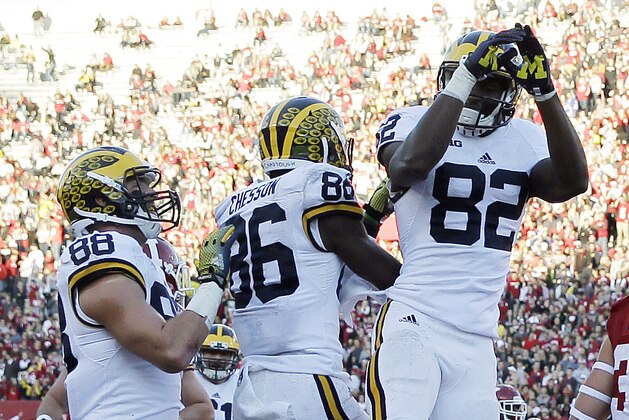 Michigan's Jehu Chesson (86) celebrates with Amara Darboh (82) and Jake Butt (88) after Chesson caught made a touchdown reception during the first half of an NCAA college football game against Indiana, Saturday, Nov. 14, 2015, in Bloomington, Ind. Indiana's Chase Dutra is at right. (AP Photo/Darron Cummings)