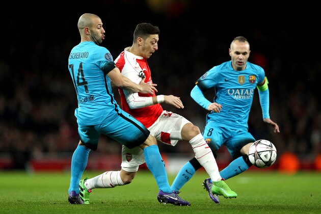 LONDON, ENGLAND - FEBRUARY 23: Javier Mascherano and Andres Iniesta of Barcelona tackle Mesut Ozil of Arsenal during the UEFA Champions League round of 16 first leg match between Arsenal and Barcelona at Emirates Stadium on February 23, 2016 in London, United Kingdom.  (Photo by Paul Gilham/Getty Images)