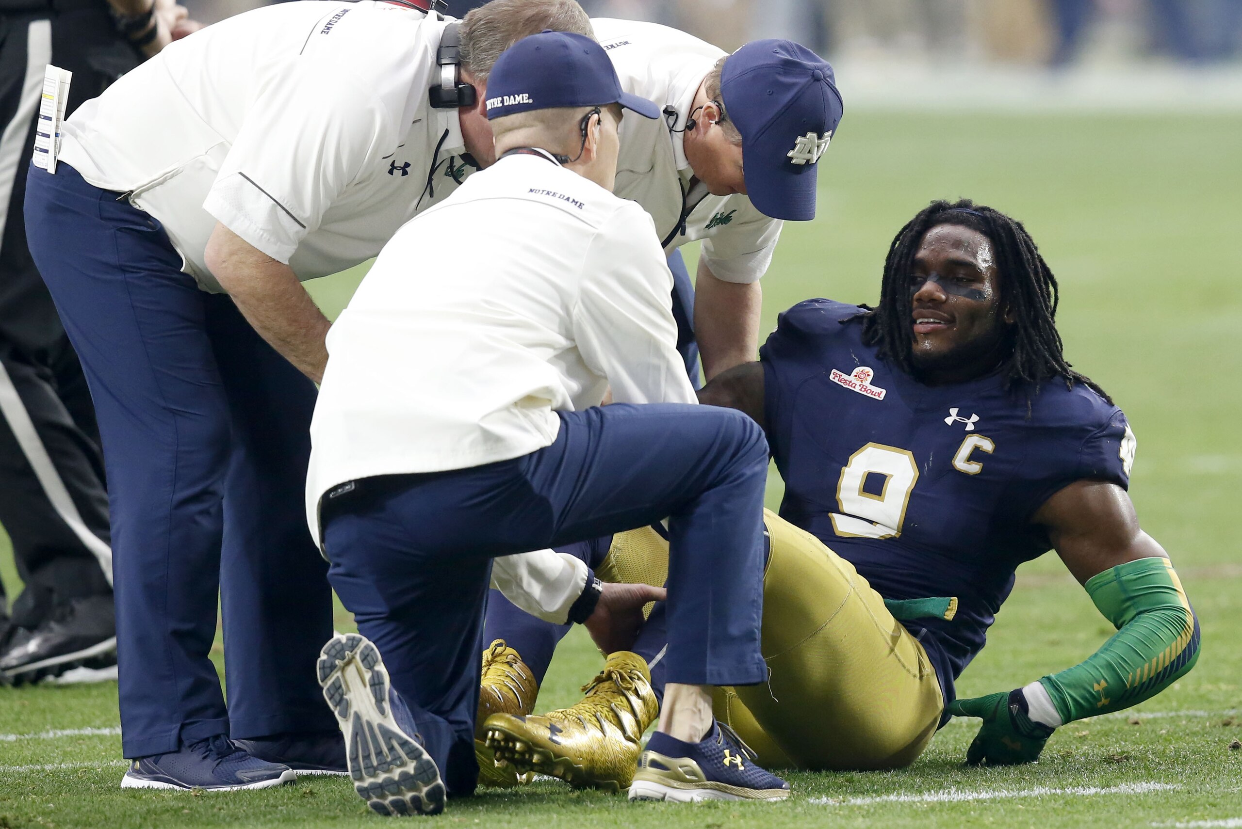 Notre Dame linebacker Jaylon Smith (9) is attended to after being injured against Ohio State during the first half of the Fiesta Bowl NCAA College football game, Friday, Jan. 1, 2016, in Glendale, Ariz.  (AP Photo/Rick Scuteri)