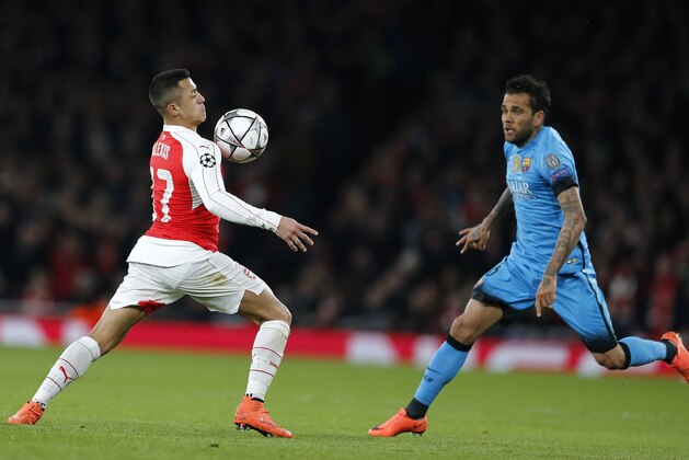 Arsenal's Alexis Sanchez, left, controls the ball as Barcelona's Dani Alves closes in during the soccer Champions League round of 16 first leg soccer match between Arsenal and Barcelona at the Emirates stadium in London, Tuesday, Feb. 23, 2016. (AP Photo/Frank Augstein)